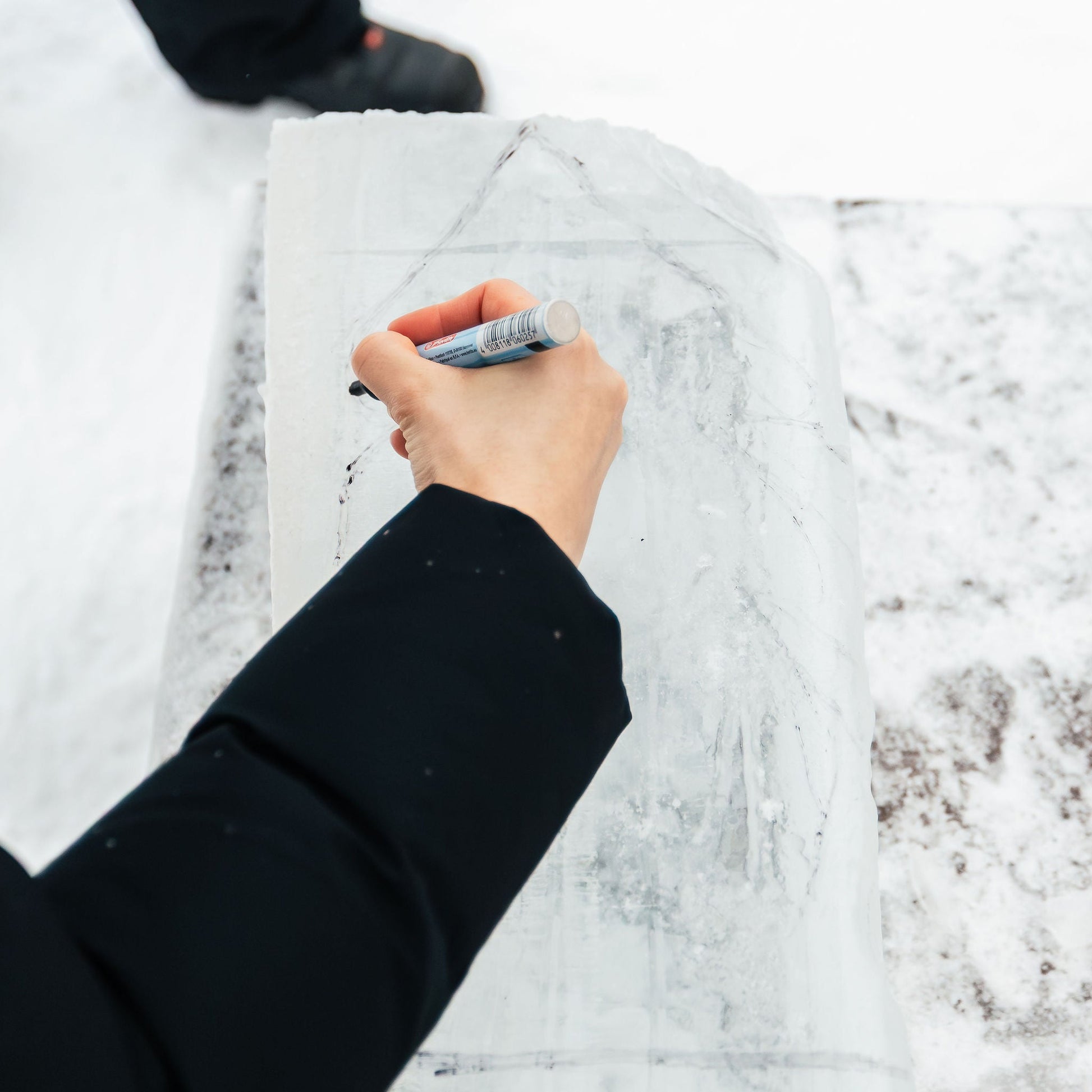 Hand writing on a textured white surface with a pen