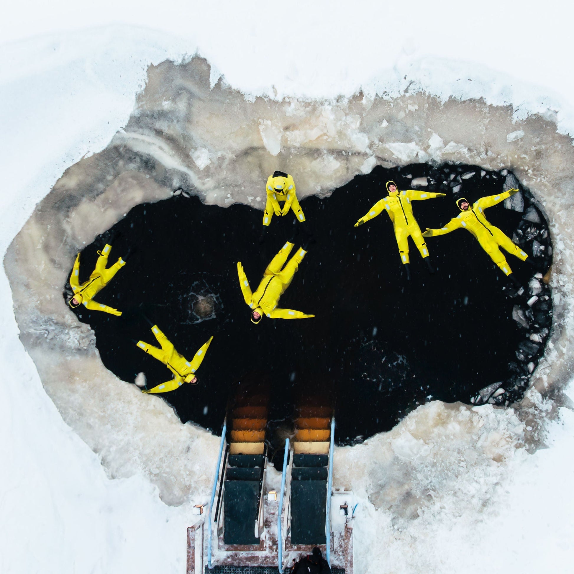Yellow figures on a butterfly-shaped ice sculpture with a snowy background