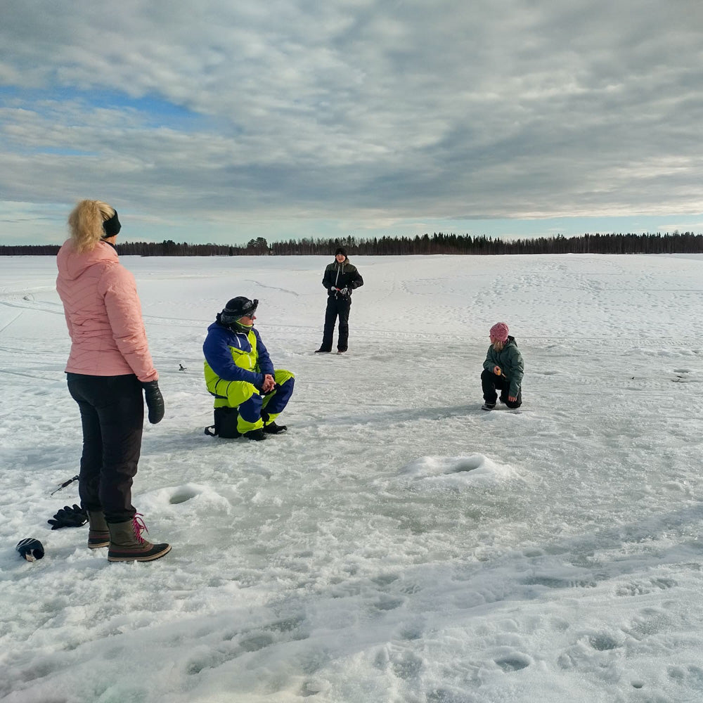 A family enjoying spring day while doing ice fishing.