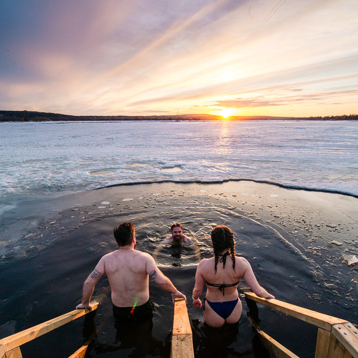 Three people enjoying ice swimming at Roiske Arctic Sauna Retreat during spring time