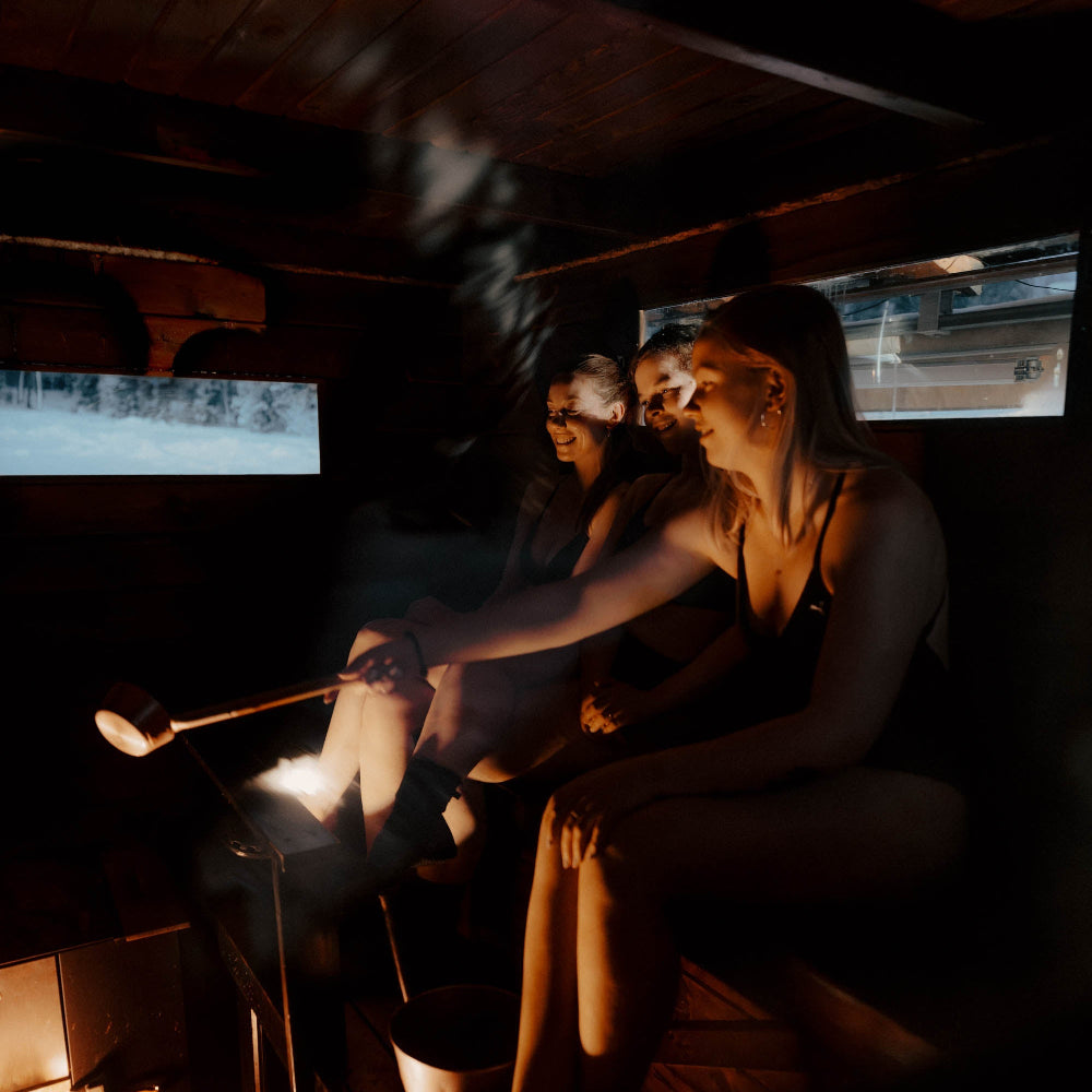 People enjoying traditional Finnish wood-heated sauna at Roiske Arctic Sauna Retreat