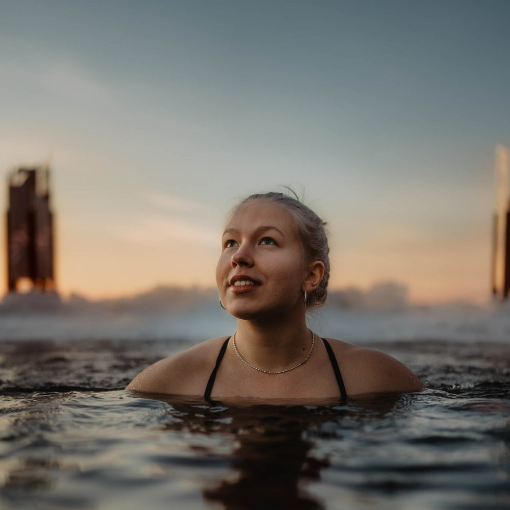 A woman enjoying ice swim during early spring at Roiske Arctic Sauna Retreat