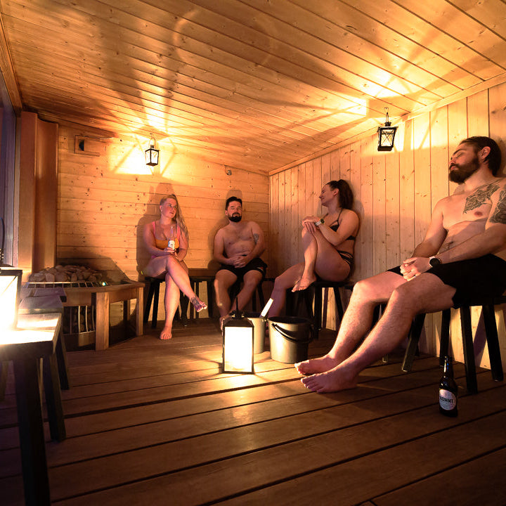 People in the sauna enjoying löyly at Roiske Arctic Sauna Retreat