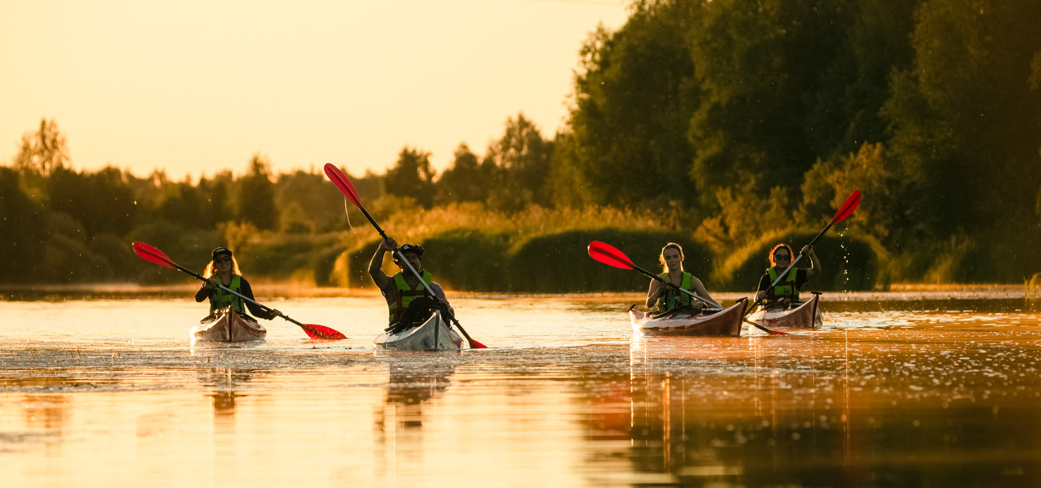 4 friends paddling at Ounas River during midnight sun