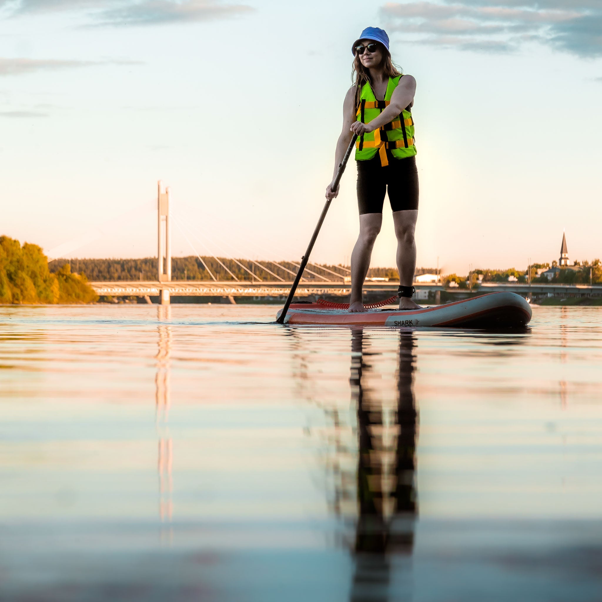 A woman doing Stand-Up-Paddling close to Lumberjack Bridge in Rovaniemi