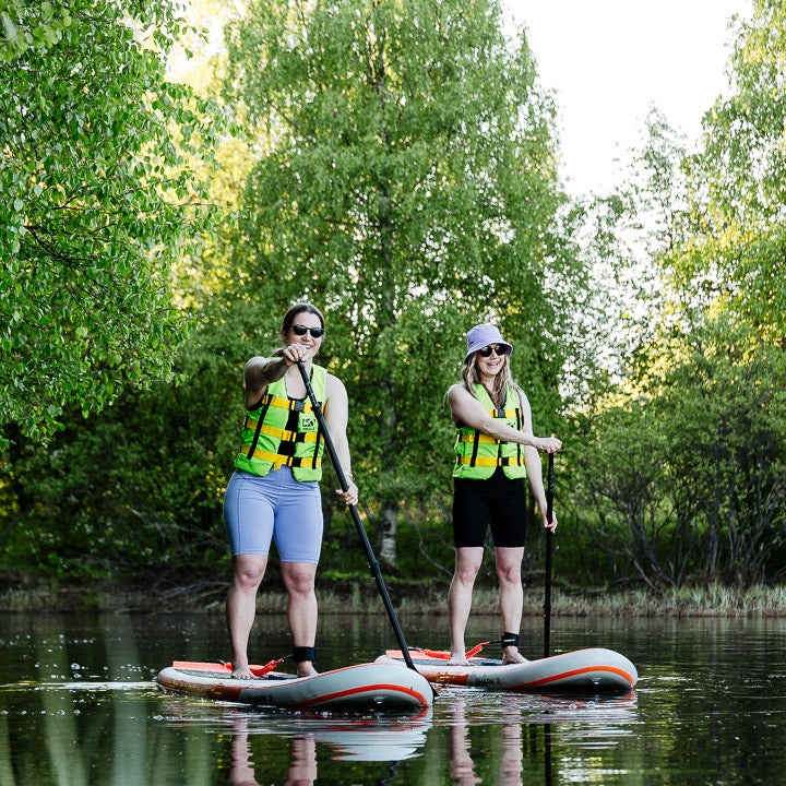Two friends enjoying the wilderness of the Ounasjoki River on SUP boards at Roiske Rovaniemi.