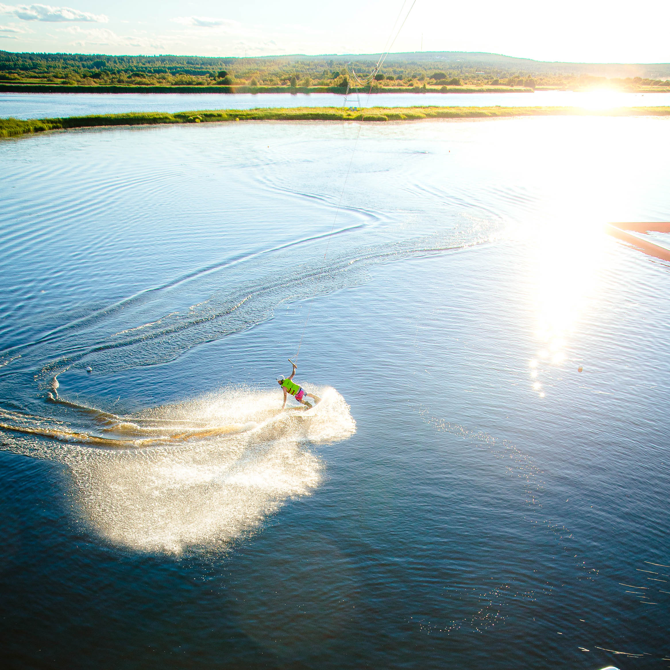 A man wakeboarding in Roiske Rovaniemi during a beautiful sunset