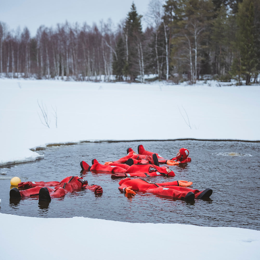 People floating in frozen river with immerion suits at Roiske Arctic Sauna Experience