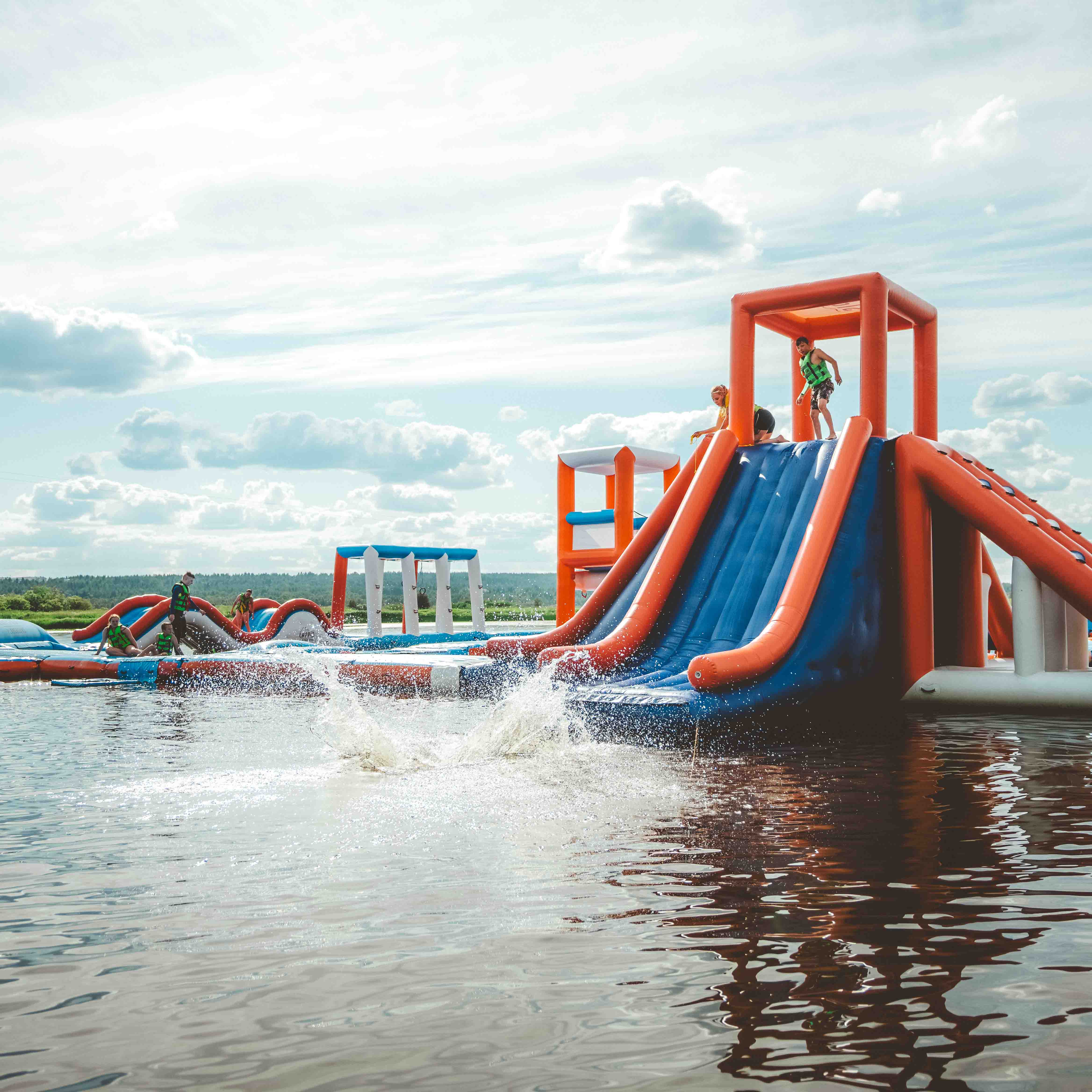 Kids are sliding down the slider at Roiske Rovaniemi floating water park