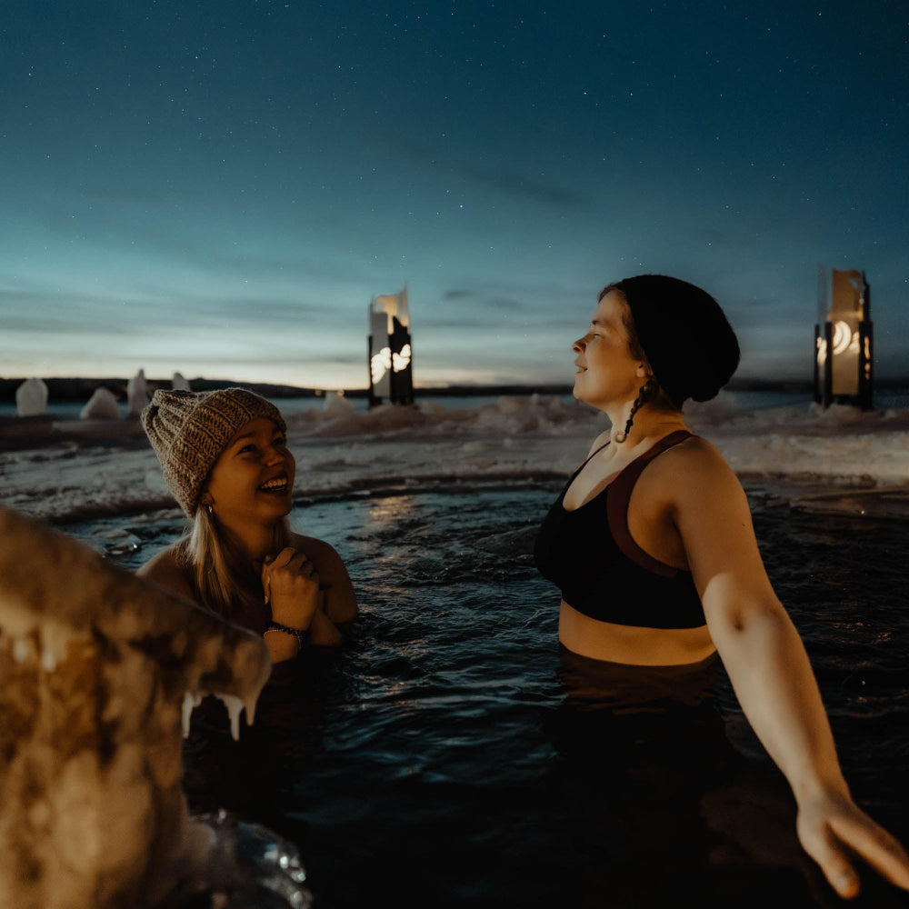 Friends are taking a dip in a cold water at Roiske Arctic Sauna Retreat
