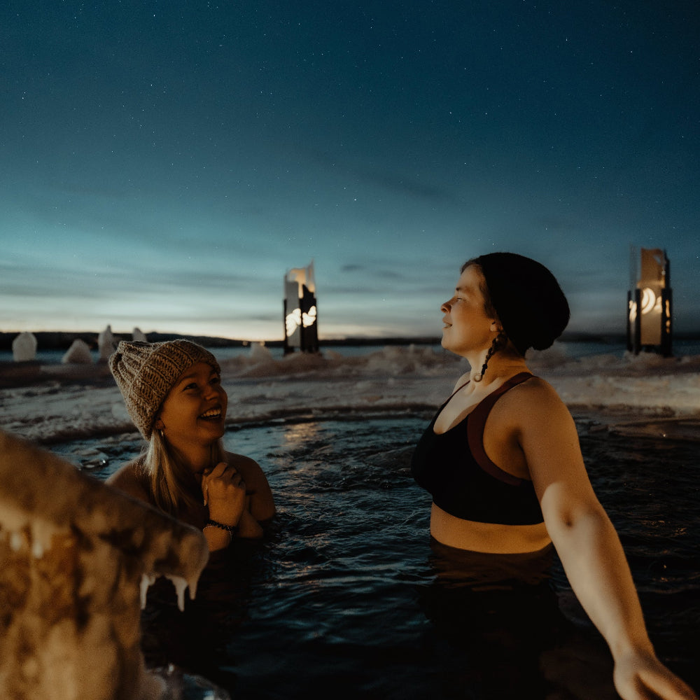 People enjoying ice swimming at Roiske Arctic Sauna Retreat