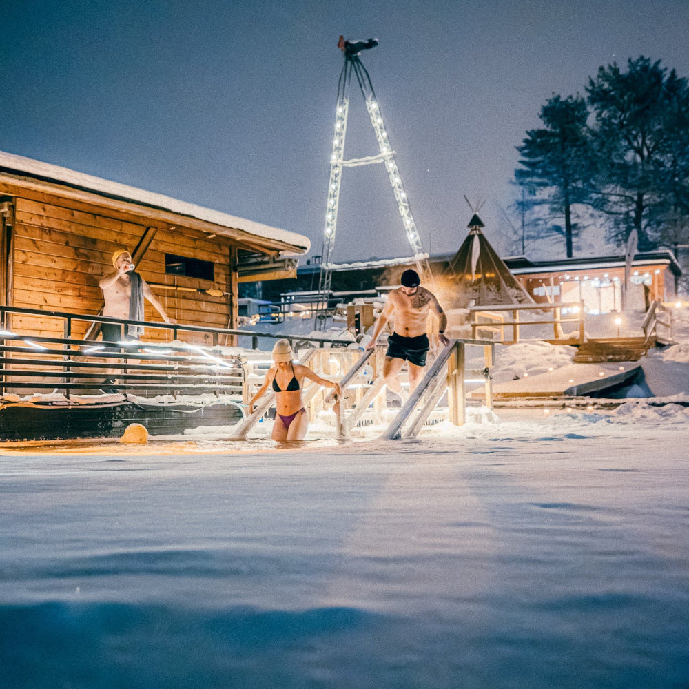 People going for a dip in the frozen river at  Roiske Arctic Sauna Retreat