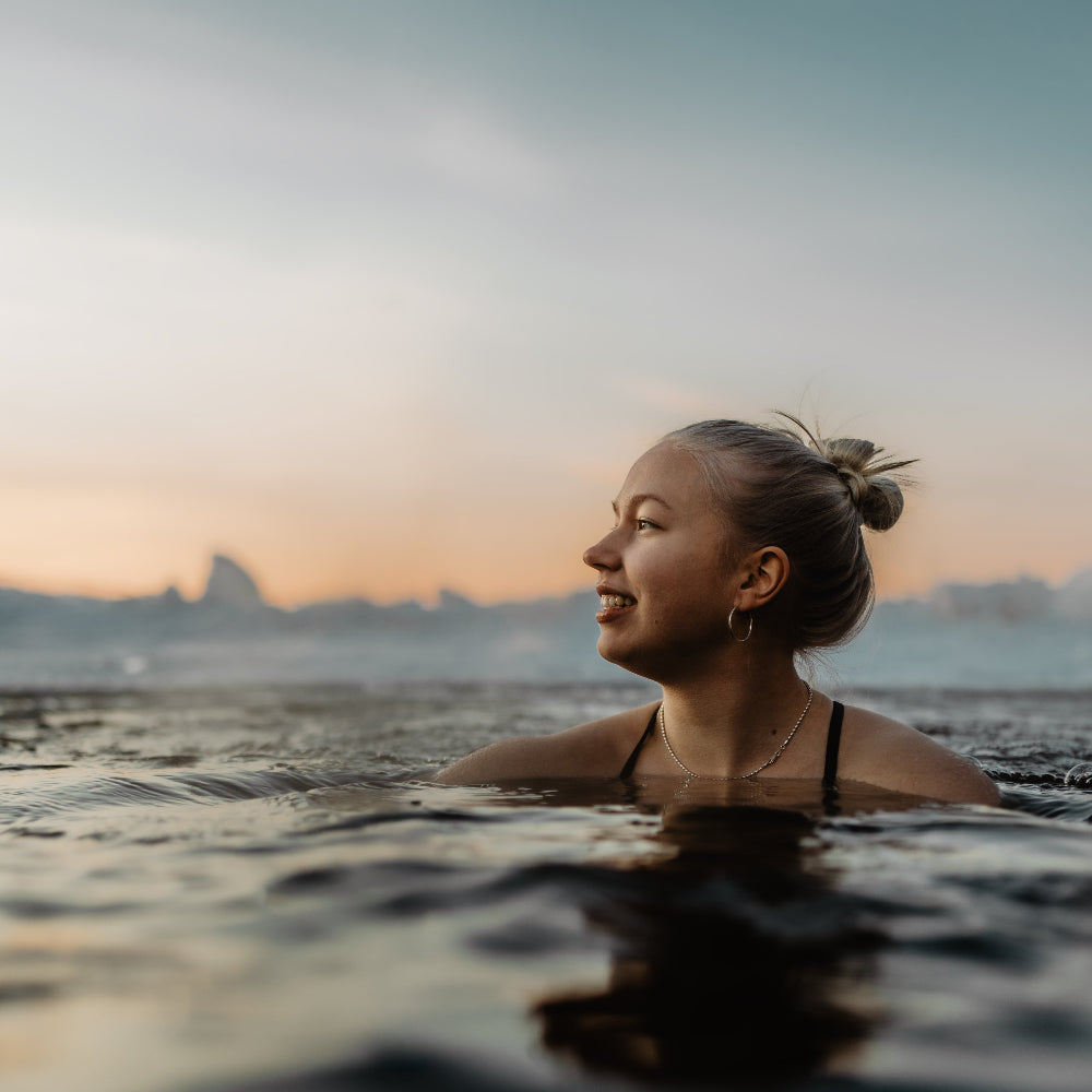 Woman enjoying ice swimming in spring weather at Roiske Arctic Sauna Retreat